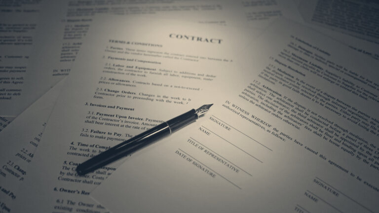 Spotlit contract pages, a fountain pen resting across the blank signature block beside NAME, TITLE and DATE fields.