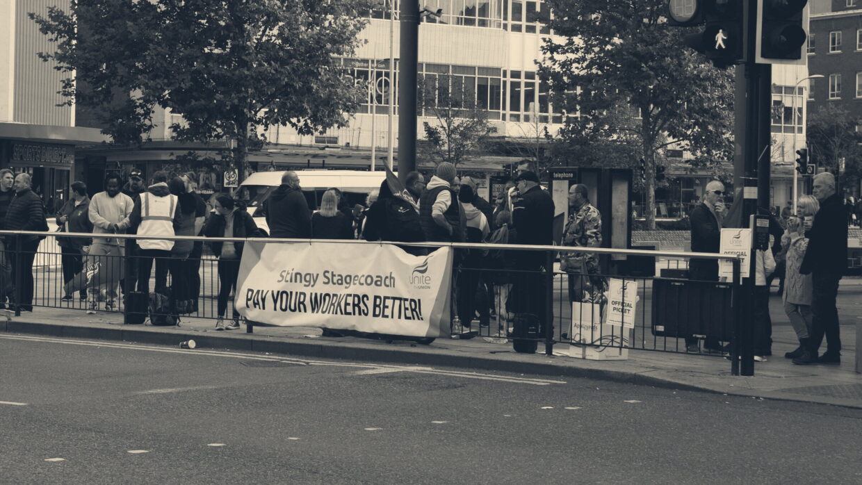 Pickets with a Unite banner reading 'Pay your workers better' outside Hull bus station
