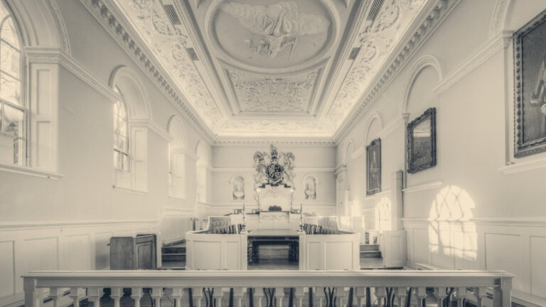 Empty Georgian courtroom in Beverley Guildhall: magistrate's bench, royal coat of arms and painted ceiling