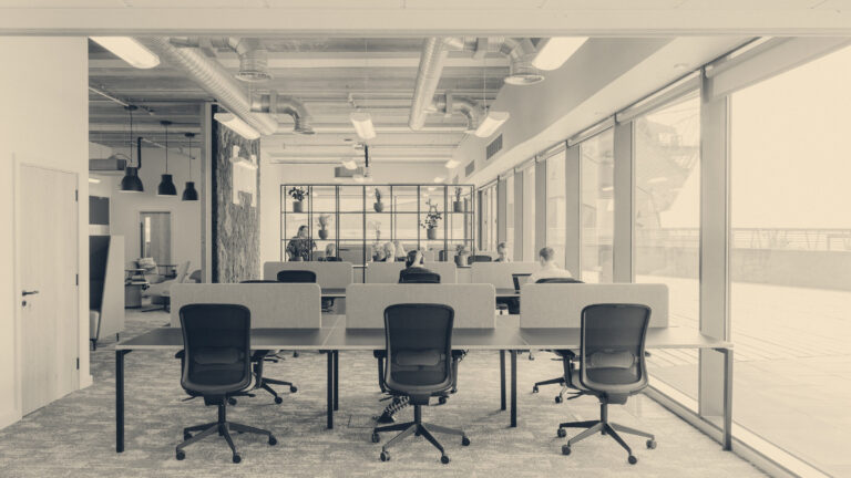 Bright open-plan coworking office in Hull: desk benches, office chairs and people working beside floor-to-ceiling windows
