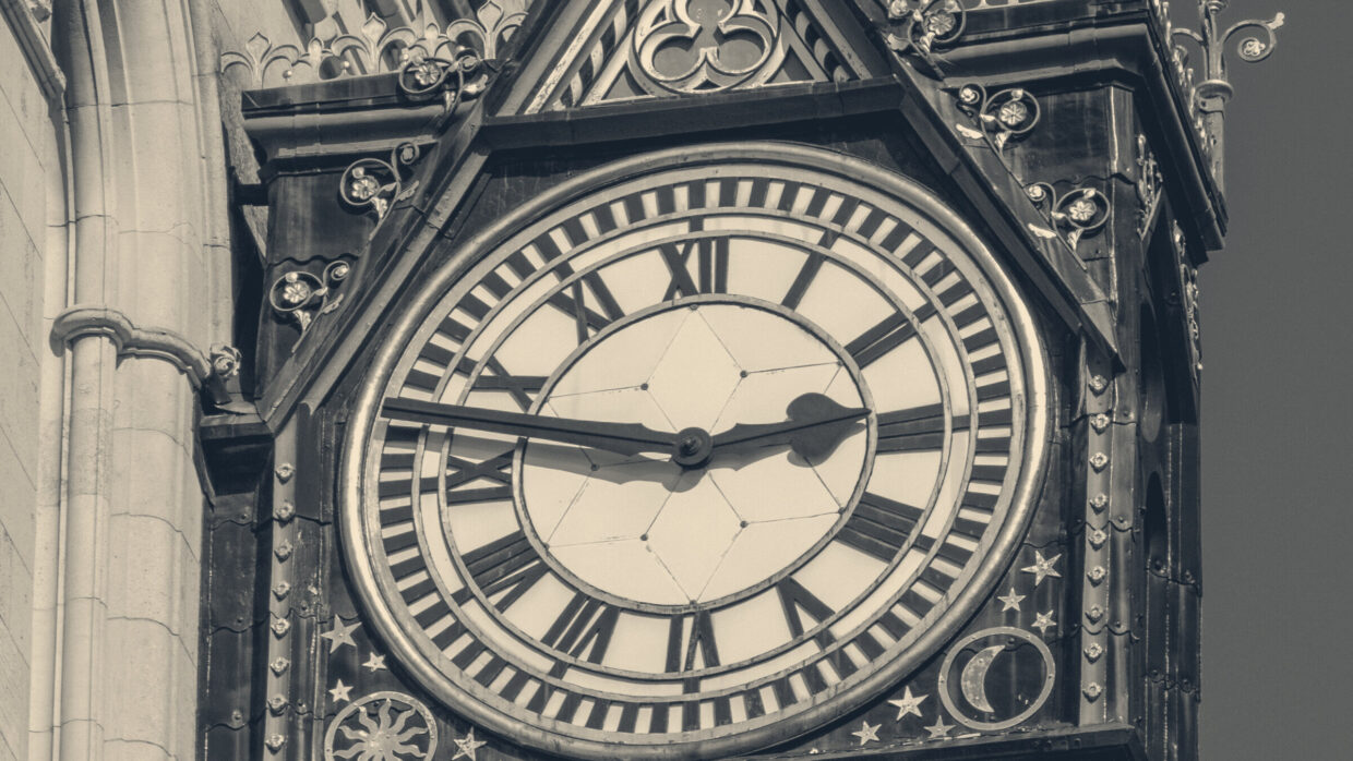 Ornate Victorian clock on the Royal Courts of Justice in London with Roman numerals, sunburst, and crescent moon